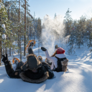 Ihmiset lumikenkäretkellä talvisessa luonnossa