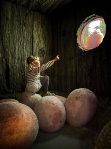 Lapsi istuu tekomunien päällä linnunpesän näyttelytilassa