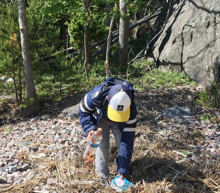 Lapsi kerää roskia luonnosta